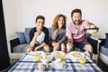 Happy caucasian family cheerful people have lunch together at home watching tv and having fun - young teenager son and adult