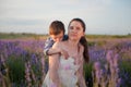 Happy caucasian family cute little boy kissing his young mother shoulder hugging her on summer lavender field in france provence Royalty Free Stock Photo