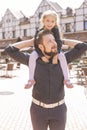 Happy caucasian family of father and daughter on a walk in european city, dressed in casual outfit. Summer daylight