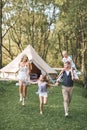 Happy Caucasian family, father mother and two little daughters, having fun outdoors in park or camping, enjoying time Royalty Free Stock Photo