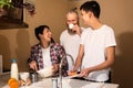 Happy caucasian family on kitchen. Mother, father and teenage son doing chores together. Positive family relationships Royalty Free Stock Photo