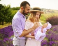 Happy caucasian family mother, father and daughter are wearing white clothes are having fun in lavender field. A couple is feeding Royalty Free Stock Photo