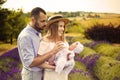 Happy caucasian family mother, father and daughter are wearing white clothes are having fun in lavender field. A couple is feeding Royalty Free Stock Photo