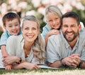 Happy caucasian family relaxing and lying on grass together in a park. Loving parents spending time with their son and Royalty Free Stock Photo