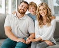 Happy caucasian family of three looking relaxed while sitting and bonding on the sofa together. Adorable little blonde Royalty Free Stock Photo