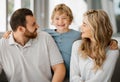 Happy caucasian family of three looking relaxed while sitting and bonding on the sofa together. Adorable little blonde Royalty Free Stock Photo