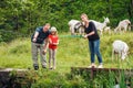 Happy Caucasian family of three people fishing together by a pond while having vacation at countryside Royalty Free Stock Photo