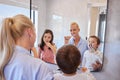 Happy caucasian family using toothbrushes and looking in mirror. Young caucasian mother in pyjamas standing with her Royalty Free Stock Photo