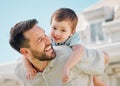 Happy caucasian father carrying playful little son on his back for piggyback ride in garden or backyard outside. Smiling Royalty Free Stock Photo