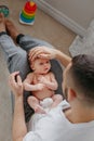 Happy Caucasian father holding newborn baby on laps knees. Man parent embracing rocking child daughter son. Authentic lifestyle Royalty Free Stock Photo