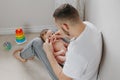 Happy Caucasian father holding newborn baby on laps knees. Man parent embracing rocking child daughter son. Authentic lifestyle Royalty Free Stock Photo