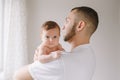 Happy Caucasian father holding newborn baby. Male bearded man parent rocking child daughter son in his hands. Authentic lifestyle Royalty Free Stock Photo