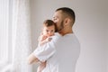 Happy Caucasian father holding newborn baby. Male bearded man parent hugging kissing child daughter son. Authentic lifestyle Royalty Free Stock Photo