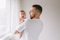 Happy Caucasian father holding newborn baby. Male bearded man parent imitating his yawning child daughter son. Authentic lifestyle Royalty Free Stock Photo