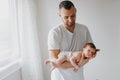 Happy Caucasian father holding newborn baby. Male bearded man parent rocking child daughter son in his hands. Authentic lifestyle Royalty Free Stock Photo