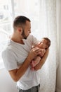 Happy Caucasian father holding newborn baby. Male man parent rocking talking to child daughter son on his hands. Authentic Royalty Free Stock Photo