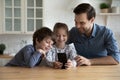 Happy Caucasian father with kids using modern smartphone together Royalty Free Stock Photo