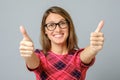 Happy caucasian female wearing red gress making thumb up sign Royalty Free Stock Photo