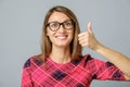 Happy caucasian female wearing red gress making thumb up sign Royalty Free Stock Photo