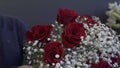 Happy Caucasian florist making bouquets of red and pink roses for valentine`s day.