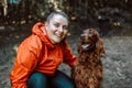 Happy caucasian girl hiker hiker walks with her cute Irish Setter dog on a walk in a summer forest Royalty Free Stock Photo