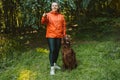 Happy caucasian girl hiker hiker walks with her cute Irish Setter dog on a walk in a summer forest Royalty Free Stock Photo