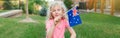 Happy Caucasian girl holding Australian flag. Smiling child sitting on grass holding Australia flag. Kid citizen celebrating Royalty Free Stock Photo