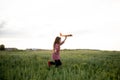 Happy Caucasian girl running across the field launches a toy airplane into the sky with her hand up. joyful child walks