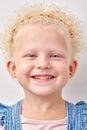 Happy caucasian kid girl has broad smile, shows perfect teeth over white studio background. Royalty Free Stock Photo