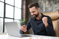 Happy Caucasian man buying things online, using smartphone, laptop and credit card, enjoying shopping in internet Royalty Free Stock Photo