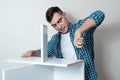 Happy Caucasian man collects white wooden table with a hand screwdriver