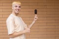 A happy Caucasian man dressed in a beige T-shirt, showing thumbs up and holding a chocolate ice cream cone Royalty Free Stock Photo