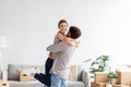 Happy caucasian man hugs and lifts his wife celebrating purchase of new apartment, couple have fun together Royalty Free Stock Photo
