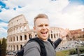 Happy caucasian man tourist with backpack taking selfie photo Colosseum in Rome, Italy. Travel trip concept Royalty Free Stock Photo
