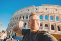 Happy caucasian man tourist with backpack taking selfie photo Colosseum in Rome, Italy. Travel trip concept Royalty Free Stock Photo