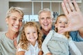 A happy caucasian mature couple bonding with their adopted kids in the living room. Two sisters relaxing with their Royalty Free Stock Photo