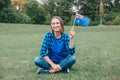 Happy Caucasian middle age woman waving Australian flag. Smiling proud citizen sitting on grass in park celebrating Australia Day Royalty Free Stock Photo