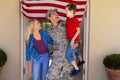 Happy caucasian military man with family standing at house entrance