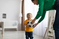 Happy caucasian mother and her toddler son playing with soccer ball at home, having fun and enjoying time together Royalty Free Stock Photo