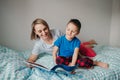 Happy Caucasian mother and son family reading book in bedroom. Mom and boy child at home spending time together. Parent talking Royalty Free Stock Photo