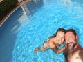 Happy caucasian people couple have fun and enjoy the swimming activity at the pool - concept of holiday summer vacation in resort Royalty Free Stock Photo