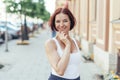 Happy caucasian red-haired girl in a t-shirt cheerful walking around the city in summer