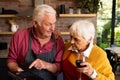 Happy caucasian senior couple cooking, drinking wine and using tablet in kitchen Royalty Free Stock Photo