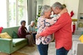 Happy caucasian senior couple dancing in front of their diverse friends at christmas time Royalty Free Stock Photo