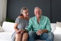 Happy caucasian senior couple in living room, on couch making video call, talking and smiling