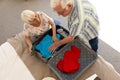 Happy caucasian senior couple packing passports into suitcase in sunny bedroom at home Royalty Free Stock Photo