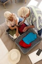 Happy caucasian senior couple packing passports into suitcase in sunny bedroom at home Royalty Free Stock Photo