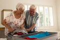 Happy caucasian senior couple packing suitcase in sunny bedroom at home Royalty Free Stock Photo