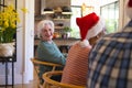 Happy caucasian senior woman celebrating with friends at christmas dinner in sunny dining room Royalty Free Stock Photo