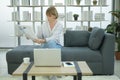 Happy  Caucasian senior woman  is relaxing , reading newspaper in living room Royalty Free Stock Photo